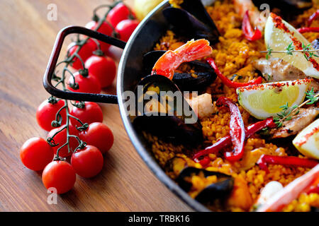 Leckere spanische Paella, Ansicht von oben. Mit stör Heilbutt-filet gekochte, geschälte Garnelen, Tintenfisch, Muscheln und Hummer mit Zitrone Stockfoto