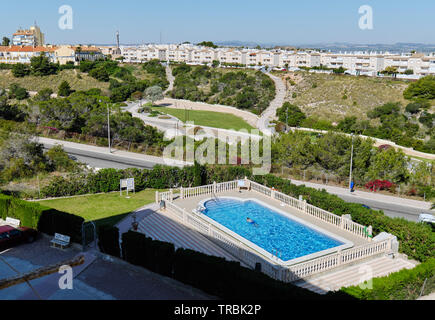 Blick von oben nicht erkennbare Person schwimmen im privaten Pool auf der anderen Straßenseite malerischen beliebter Ort für Entspannung aromatische Park, Torrevieja Stockfoto