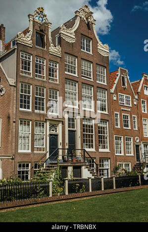 Typische Häuser und grünen Garten des Begijnhof, einem mittelalterlichen Gemeinschaft in Amsterdam. Stadt mit riesigen kulturelle Aktivität, Kanäle und Brücken in den Niederlanden. Stockfoto