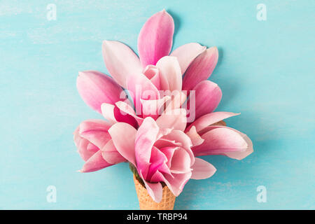 Pink Magnolia Blumen Blumenstrauß in Eis auf blauem Hintergrund. Hochzeit oder Urlaub Hintergrund. Flach. nach oben aus der Nähe ansehen. Stockfoto