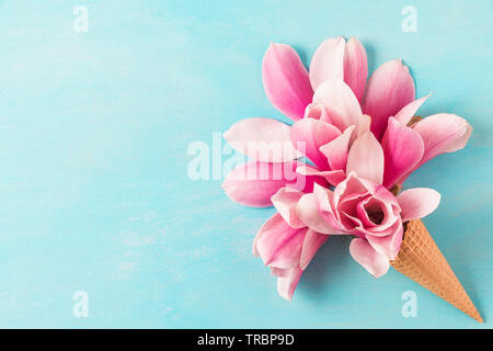 Pink Magnolia Blumen Blumenstrauß in Eis auf blauem Hintergrund. Hochzeit Hintergrund. Flach. Ansicht von oben mit der Kopie Raum Stockfoto