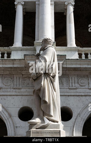 Die restaurierte Statue von Andrea Palladio gesehen mit den Spalten der Basilika Palladiana im Hintergrund, Vicenza, Italien Stockfoto