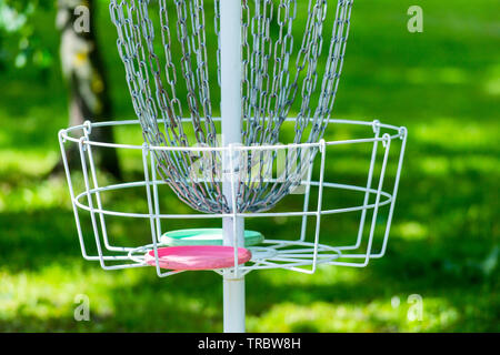 Metall-Korb in das Gras und die Bäume in der Mitte des Parks. Warenkorb verwendet Frisbee Golf durch das Werfen von Disc in den Metallkorb zu spielen Stockfoto