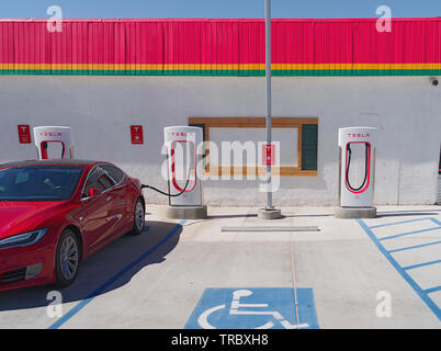 Tesla-Ladestation und ein Auto-Aufladen in der Mojave-Wüste. Stockfoto