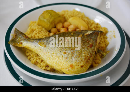 Ein traditioneller Nordafrikanischer Schüssel Couscous mit Fisch (Goldbrasse), Kichererbsen und Gemüse, serviert in einem Restaurant in der Medina von Tunis, Tunesien. Stockfoto