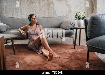 Junge schöne Frau auf der Couch Stockfoto