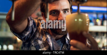 Close-up des Menschen Zeichnung Bier aus Tippen Stockfoto