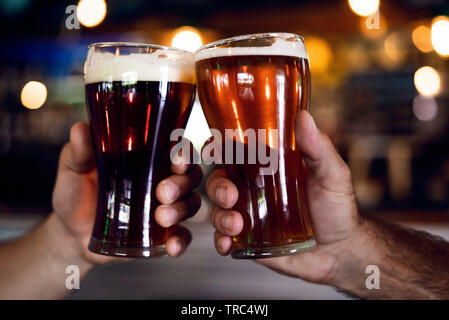 Hände toasten Biergläser Stockfoto