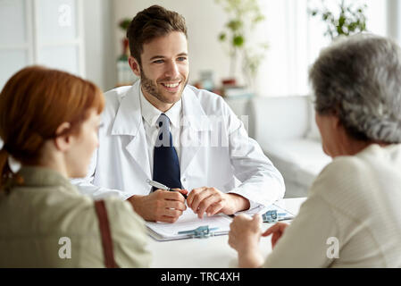 Lächelnd Arzt im Gespräch mit älteren Patienten Stockfoto