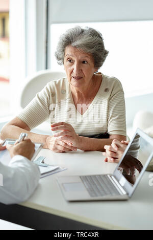 Ältere Frau in die Klinik sitzen Stockfoto