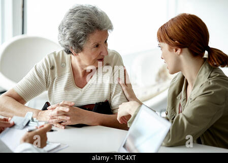 Frau im Gespräch mit ihrer Mutter in der Klinik Stockfoto