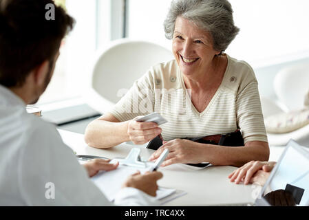 Ältere Frau im Gespräch mit dem Arzt in der Klinik Stockfoto