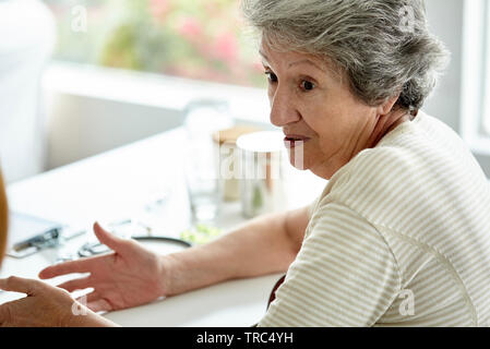 Ältere Frau in Klinik sitzen Stockfoto