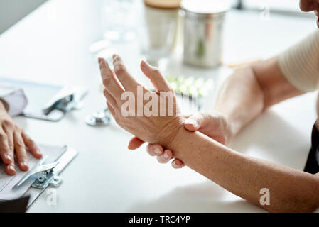 Ältere Frau ihre Hand zeigen, Arzt Stockfoto