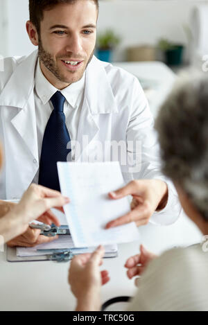 Arzt Rezept für Patienten geben Stockfoto