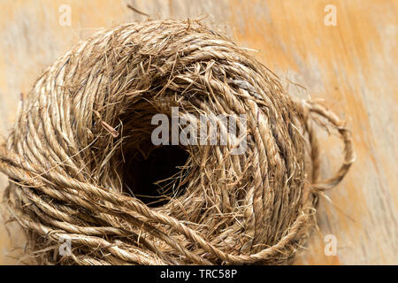 Strang Kugel aus Jute Garn auf hölzernen Hintergrund, Nahaufnahme, Makro Stockfoto