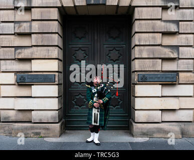 Scottish Piper spielt Dudelsack auf ausserhalb von Edinburgh Royal Mile High Court in der Altstadt von Edinburgh, Schottland, Großbritannien Stockfoto