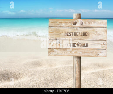 Top 10 Strände der Welt Meldung auf der hölzernen Planken Schild am Strand verschwommenen Hintergrund. Tropischen Inselparadies. Sandy Shore waschen b Stockfoto