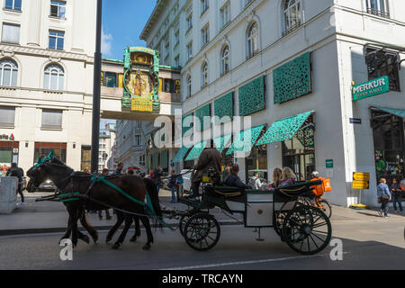 Wien Tourismus, Blick auf eine Kutsche mit Touristen und Geschäftsreisende, die Ankeruhr in Hoher Markt in der Altstadt von Wien, Österreich. Stockfoto