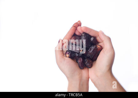 Palm Termine isoliert auf einem weißen Hintergrund. Handvoll Dattelpalmen. Frau mit Frucht in die Hände. Früchte auf weißem Hintergrund. Stockfoto