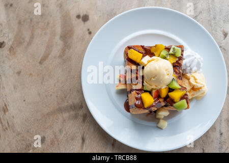 Honig toast Eis Vanille mit geschnittenem Obst und Schokoladensauce auf weiße Platte Stockfoto