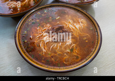 Chinesische Nudelsuppe mit Rindfleisch in würziger Suppe an der Schale Stockfoto