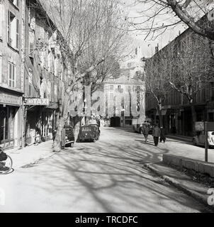 1950s, historisch, Frankreich, Sisteron, Blick auf eine Straße in der Altstadt, mit Autos und Transport aus der Zeit, zeigt einen Bus aus der Zeit, der nach Digne fährt. Die Stadt wurde ursprünglich im 11.. Jahrhundert erbaut, mit späteren Ergänzungen und liegt zwischen den Alpen und dem Mittelmeer. Stockfoto