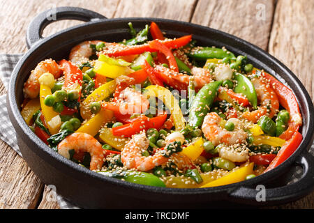 Gemüse braten mit Garnelen und Sesam close-up Rühren in der Pfanne auf den Tisch. Horizontale Stockfoto