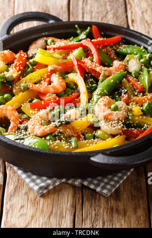 Köstliche asiatische Brj von Garnelen mit Gemüse rühren, Sesam close-up in einer Pfanne auf dem Tisch. Vertikale Stockfoto