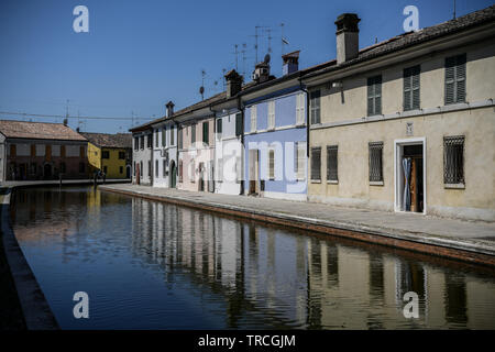 Bunte Häuser in die Gewässer des Canal in Comacchio, Emilia Romagna, Italien. Das Fischerdorf liegt in einer Lagune, umgeben von Gelegen Stockfoto