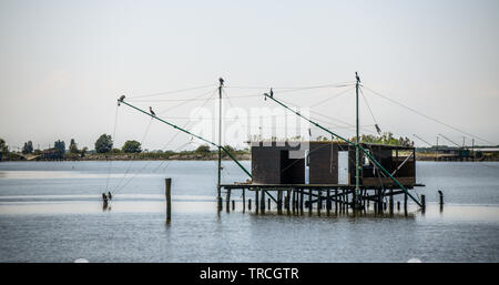 Die traditionelle Fischerei Hütte auf Stelzen mit hängenden Netzen in Comacchio Tal, Emilia Romagna, Italien. Das Fischerdorf liegt in einer Lagune, surro gelegen Stockfoto