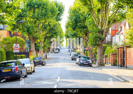 London, Großbritannien - 15 September, 2018 - Blick auf einer kleinen, mit Bäumen gesäumten Straße bergauf mit einer Schule Kinder Zeichen in West Hampstead Stockfoto