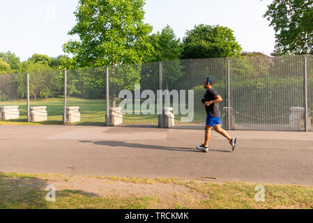 Jogger an temporären Einzäunung. Sicherheit rund um Winfield House, Regent's Park, London, UK für den Staatsbesuch von US-Präsident Donald Trump. Stockfoto