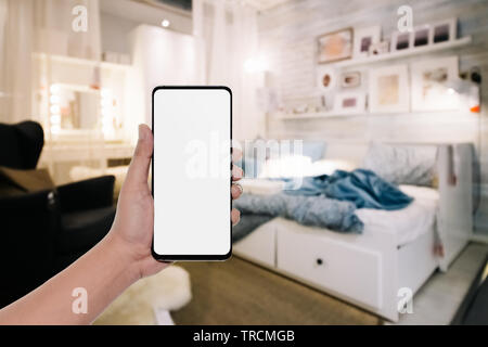 Mockup Bild von Hand mit modernen Handy mit leeren Kopie Raum desktop Bildschirm für ihre Werbung im Schlafzimmer Stockfoto
