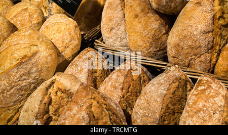 Frische handgefertigte artisan Brote für den Verkauf in einem Korb. Stockfoto