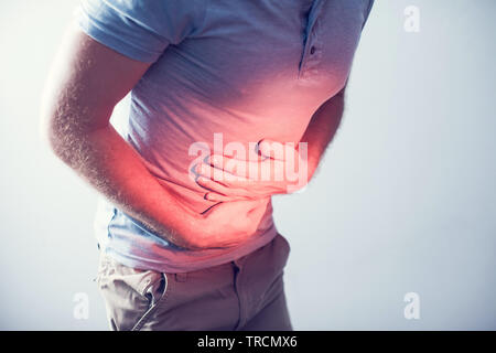 Menschen, Gesundheitswesen und Problem Konzept - unglückliche Menschen leiden unter Bauchschmerzen über grauer Hintergrund Stockfoto