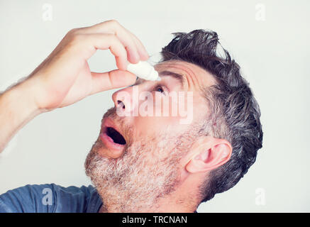 Ein Mann mit Augentropfen in den Augen Stockfoto