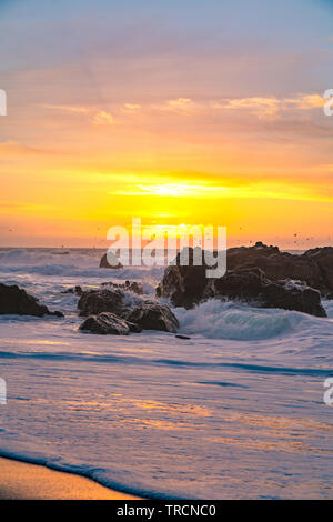 Wellen in Bewegung an Land wie die Sonnenuntergänge am Horizont entlang der berühmten Highway 1 in der Nähe von Big Sur, Kalifornien Stockfoto