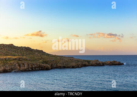 Bunte Sonnenaufgang über einem felsigen Küstenlinie in Mykonos, Griechenland. Stockfoto