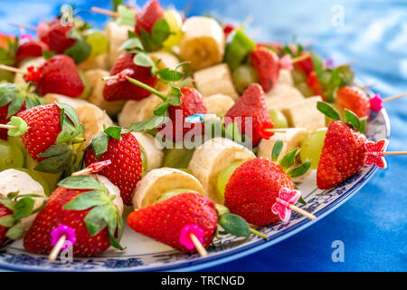 Erdbeeren und andere exotische Früchte mit Stöcken festgesteckt, Essen Stockfoto