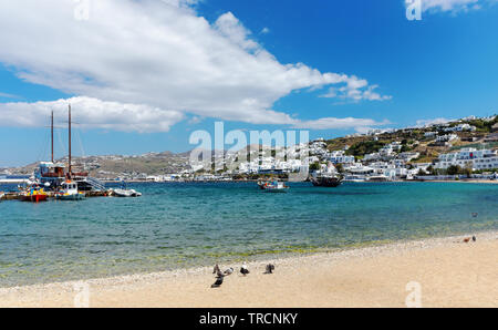 Mykonos, Griechenland - Mai 2019: Segelboote und andere Fischereifahrzeuge, die in einem super klar und das türkisfarbene Wasser vor der Küste von Mykonos Stadt (Chora) Griechenland. Stockfoto