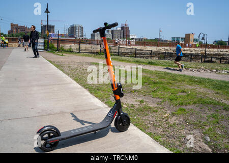 Minneapolis, MN - Juni 2, 2019: ein Spin Marke dockless, elektrische Gemeinschafts-Roller auf einem Bürgersteig in Mill Ruinen geparkt und wartet auf seine nächste Rider Stockfoto