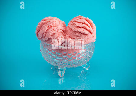 Eine Erdbeere Eisbecher auf einem blauen Hintergrund Stockfoto