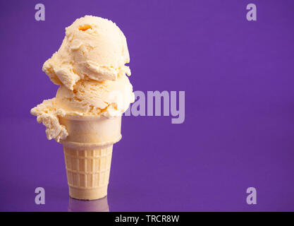 Double Scoop Vanille Eis auf einem violetten Hintergrund Stockfoto