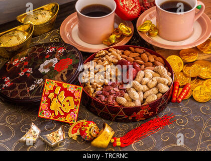 Das chinesische Neujahr snack Box, die traditionell für die Gäste serviert. Chinesisches Symbol für Rautenform bedeutet 'Glück'. Symbole auf Münzen bedeutet Vermögen. Mini Stockfoto