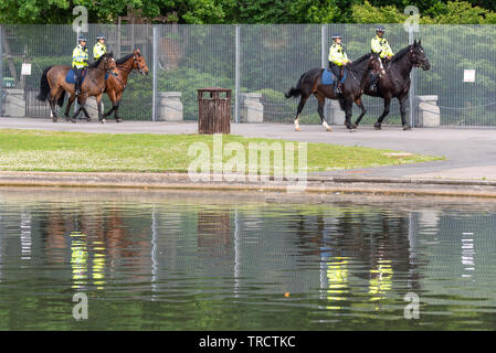 Berittene Polizei patrouilliert Zaun. Sicherheit rund um Winfield House, Regent's Park, London, UK für den Staatsbesuch von US-Präsident Donald Trump. Stockfoto