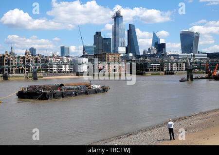 Blick auf die Stadt London auf die Skyline der Stadt von Bankside, Binnenschiff und Mann stand am Riverside telefonieren mobil in London UK KATHY DEWITT Stockfoto