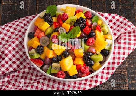 Frische Rainbow Obst Salat auf einem Holztisch Stockfoto