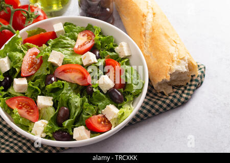 Frischen griechischen Salat mit Oliven, Tomaten und Feta Käse auf einem konkreten countertop Stockfoto