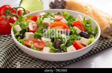 Frischen griechischen Salat mit Oliven, Tomaten und Feta Käse auf einem konkreten countertop Stockfoto